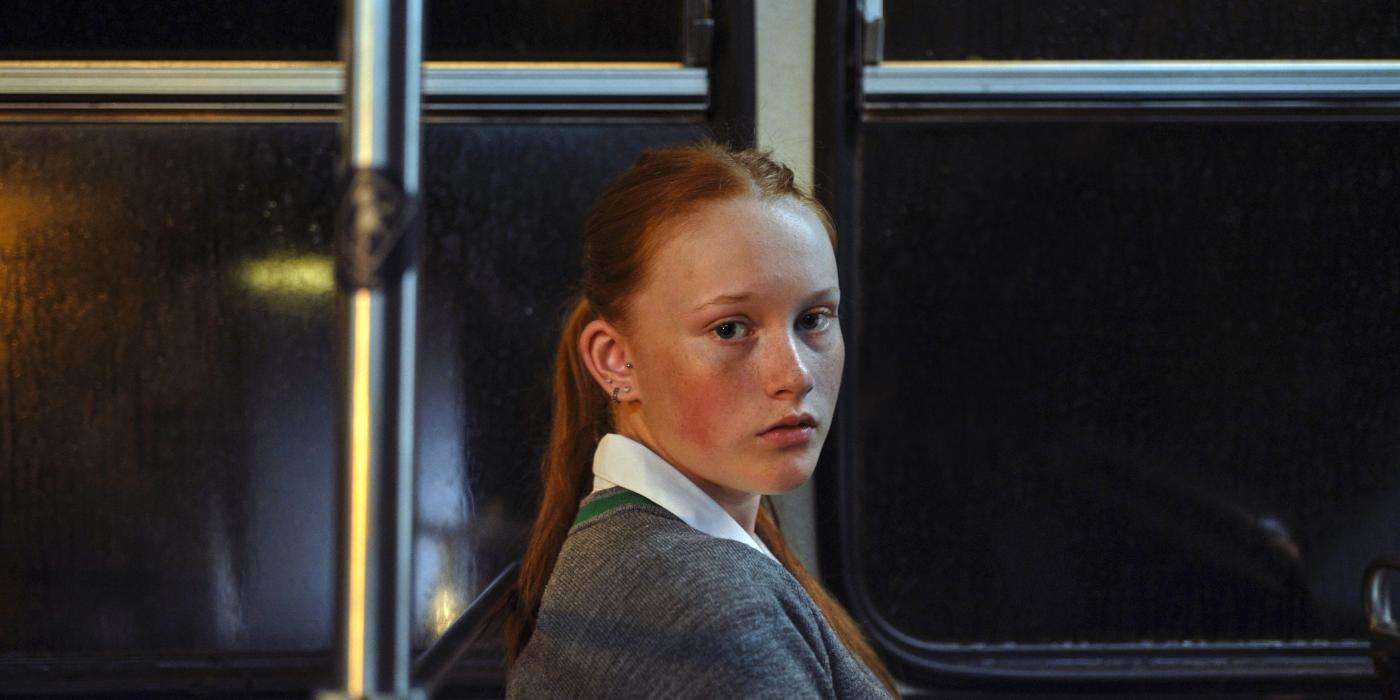 Girl on a bus looking at camera